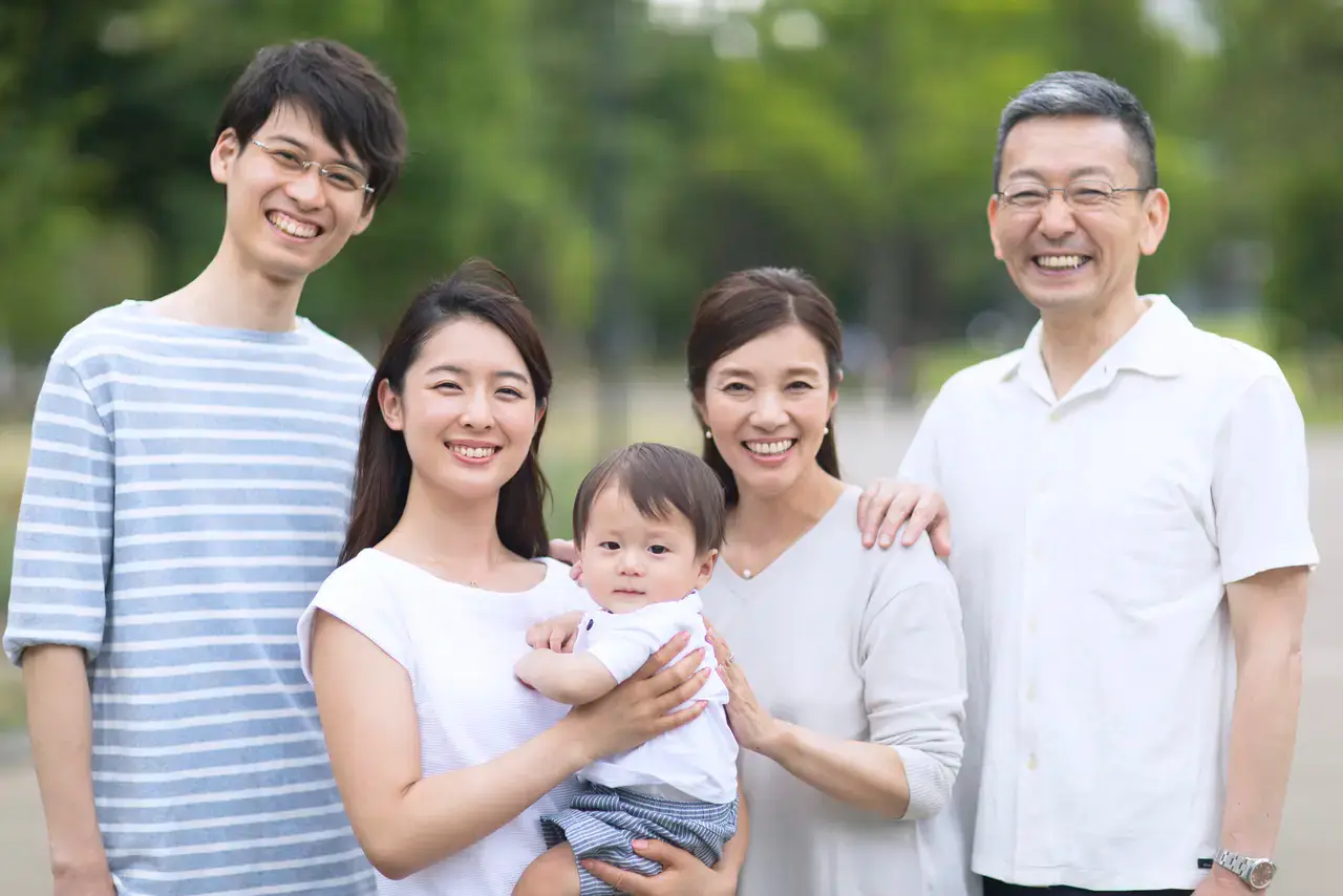 赤ちゃんを抱いて微笑む家族の集合写真|「その先の幸せ」を象徴する一枚