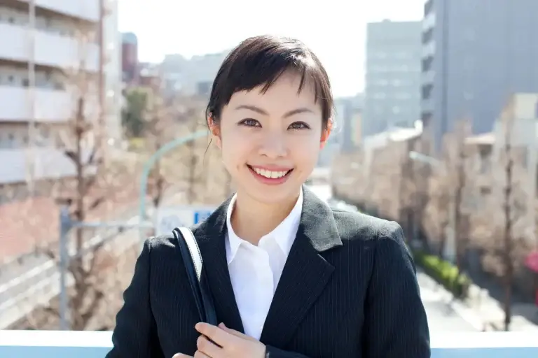 "笑顔でこちらを見つめる20代女性。明るく前向きな印象の婚活イメージ"