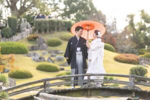 岡山後楽園で和装の前撮りをする新郎新婦。紅葉の中、穏やかに微笑み合う姿。