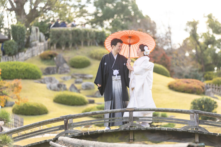 岡山後楽園で和装の前撮りをする新郎新婦。紅葉の中、穏やかに微笑み合う姿。