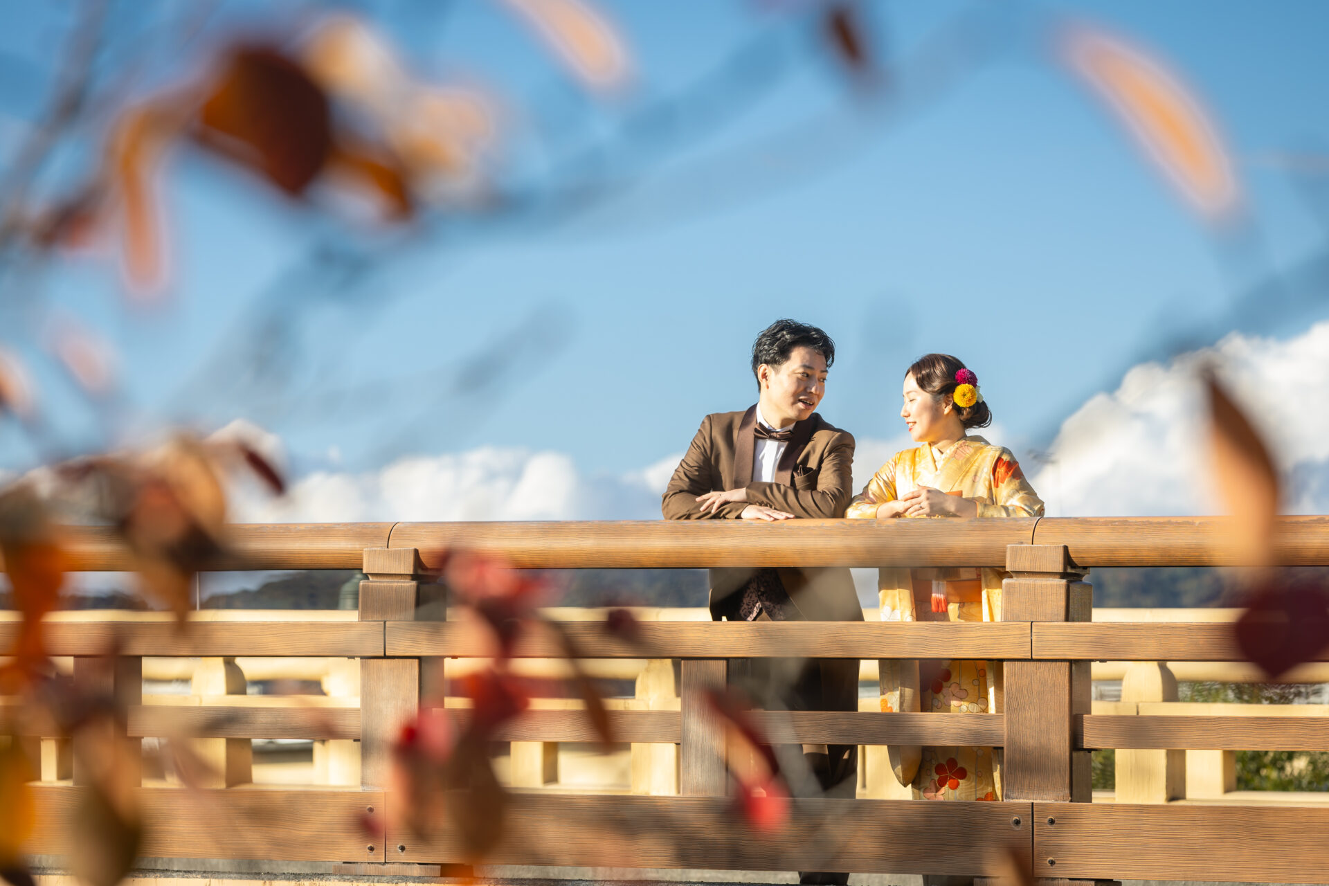 岡山の町並みを背景に、新婦が和装、新郎がタキシード姿で並ぶ前撮り風景