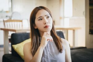 婚活の違和感に悩む女性がリビングで静かに考え込んでいる様子