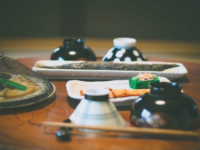 昭和の食卓に並ぶ白ごはん、味噌汁、焼き魚、漬物と湯気の立つ朝の風景