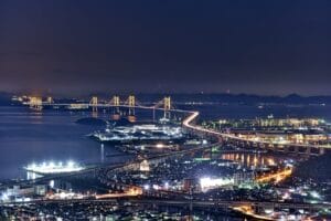 ライトアップされた瀬戸大橋の夜景。海面に光が映り込む幻想的な風景。