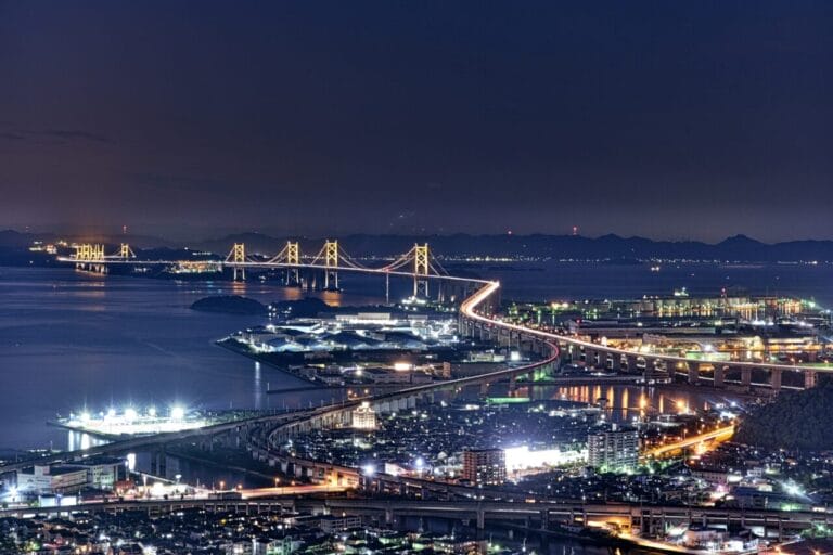 ライトアップされた瀬戸大橋の夜景。海面に光が映り込む幻想的な風景。
