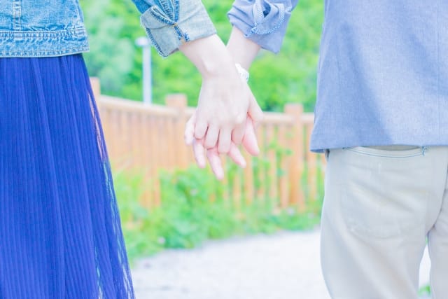 手をつないで歩くカップルの後ろ姿