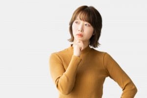 お見合いで表情がかたいと悩む女性が、真剣な表情で考え込んでいる様子