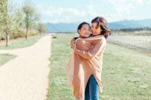 抱き合う母親と子どもが安心した表情を見せている様子