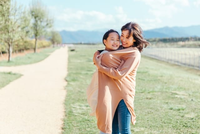 抱き合う母親と子どもが安心した表情を見せている様子