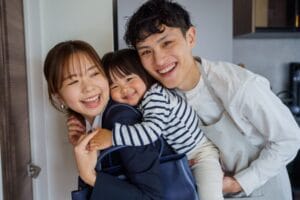 母親がおんぶする子どもに、少し距離を保ちながら顔を寄せる再婚相手の様子