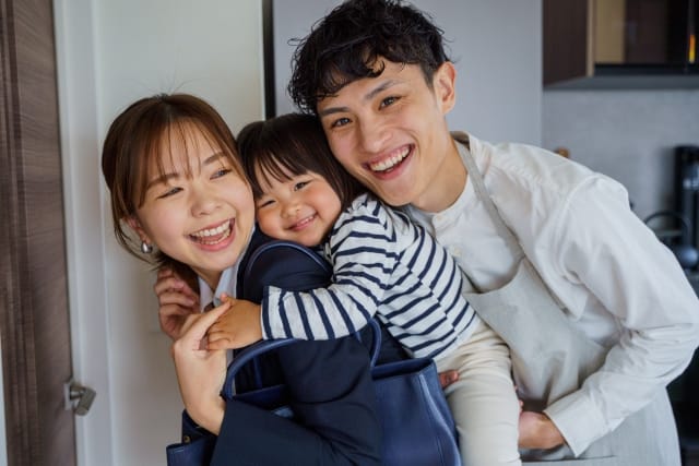 母親がおんぶする子どもに、少し距離を保ちながら顔を寄せる再婚相手の様子