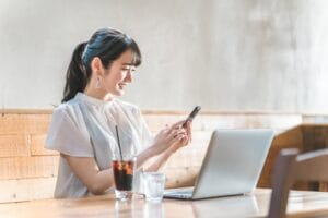 パソコンの前で笑顔の女性｜婚活で大卒以上を条件にする理由を考える