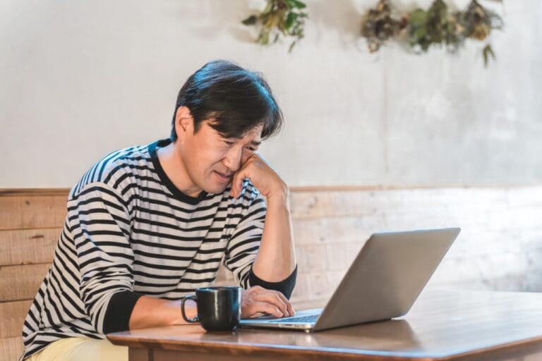 婚活がうまくいかず、パソコンを見ながら悩む岡山の30代男性