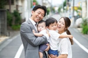 笑顔で会話を楽しむ4人家族の様子｜笑いの絶えない家庭をイメージした写真