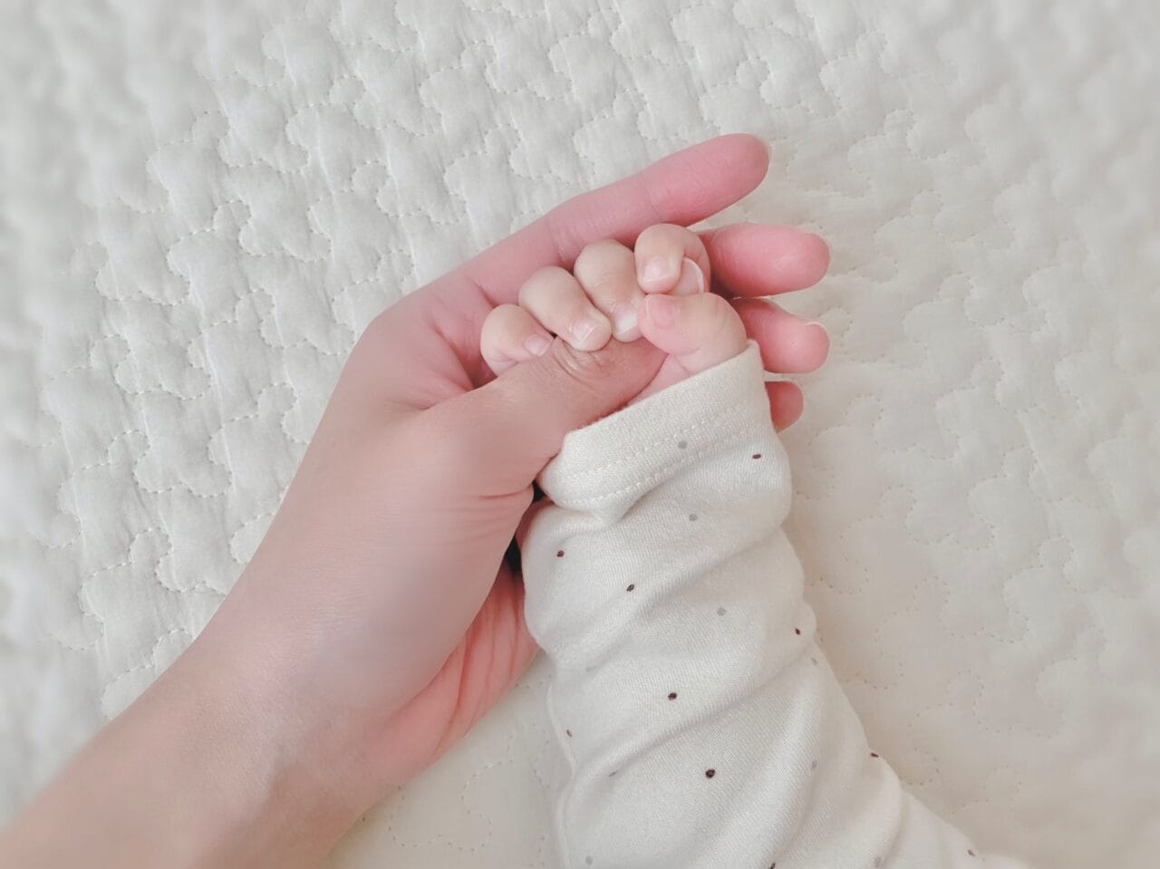 母親の手を握る赤ちゃんの小さな手のアップ写真｜岡山の結婚相談所bluebees成婚後の出産報告