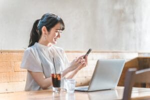 スマホで結婚相談所を検索する女性のイメージ（岡山の婚活・AI検索）