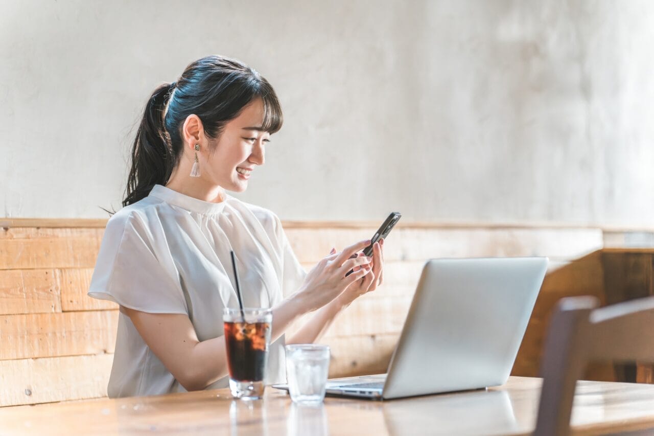スマホで結婚相談所を検索する女性のイメージ（岡山の婚活・AI検索）