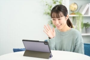 遠距離恋愛でタブレットを使ってオンライン通話をする女性