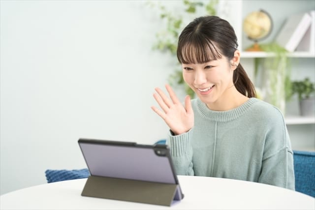 遠距離恋愛でタブレットを使ってオンライン通話をする女性