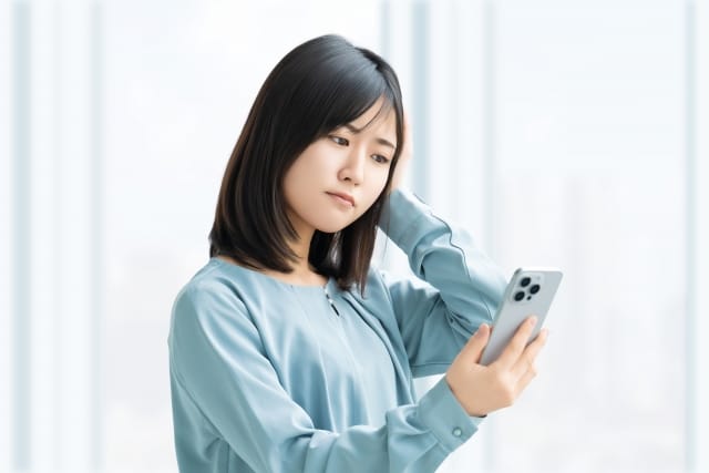 スマートフォンを見ながら結婚相談所選びについて考える女性
