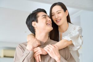 笑顔でバックハグをする夫婦。人生を支え合うパートナーシップを表現したイメージ
