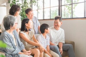 三世代の家族が笑顔でくつろぐ様子。幸せな家族の時間を象徴する風景